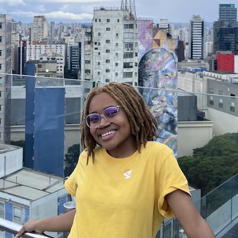 student smiling in front of buildings in the city
