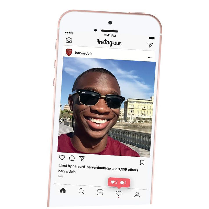 A smartphone displays an Instagram post of a smiling person wearing sunglasses.