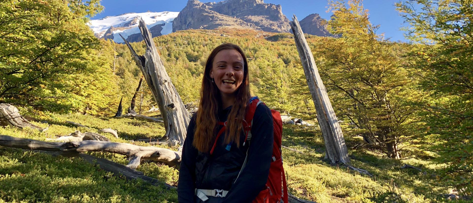 Hiker smiling in a sunlit mountain forest