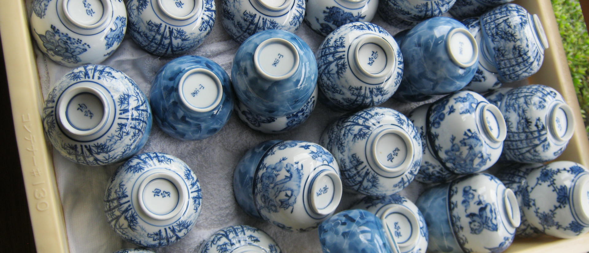 A tray of blue and white porcelain bowls arranged upside down.