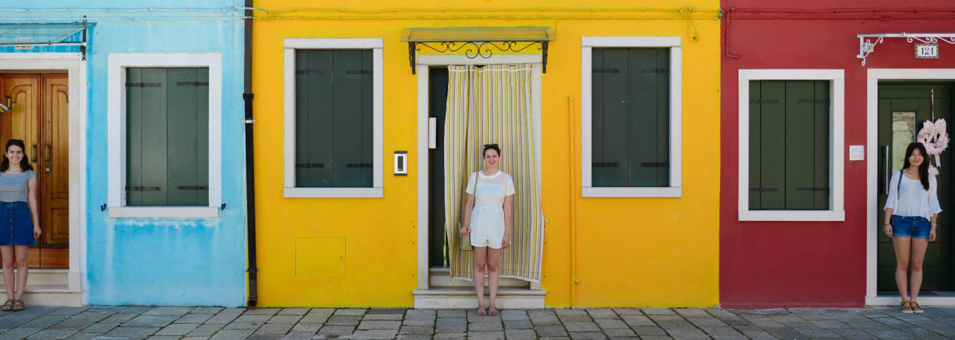 a student standing in front of colorful houses